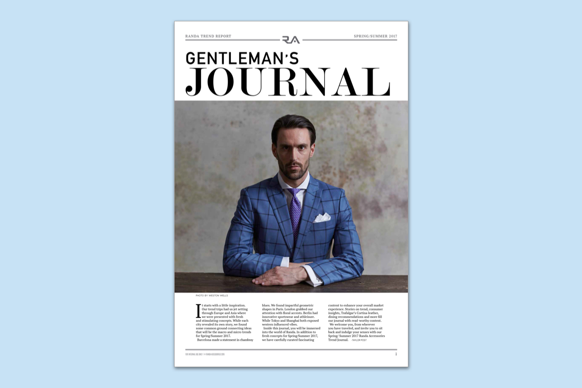 Magazine cover with man model sitting in dark blue striped suit